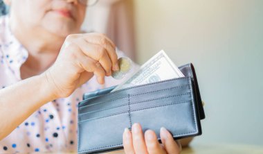 İçinde bozuk paralar olan siyah cüzdan ve fotokopi alanı olan Amerikan Doları olan mutlu yaşlı bir kadın. Yaşlılıkta finansal güvenlik kavramı