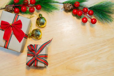 Kahverengi Noel hediye kutuları, üzerinde köknar dalları ve ahşap masa süsleri var. Boşluğu kopyala.