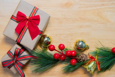 Çam kozalakları, dallar, hediyeler ve ahşap arka planda altın süslemeler olan bir Noel sahnesi. Boşluğu kopyala.