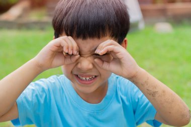 Yeşil ağacın arka planında küçük bir çocuğun portresi, yaz parkında yürüyor ve oynuyor..