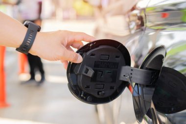 Siyah bir tankı açarken adamın elini kapat. Arabanın benzin kapağını aç. Yakıt ikmali Benzin İstasyonu Konseptinde. Seçici odak.