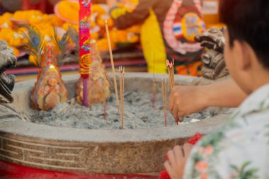 Çinliler tütsü çubukları yakmak için tapınağa gider ve iyi bir başlangıç dilemek için tapınaklara dua ederler. Seçici odak.