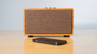 Kablosuz hoparlör, ahşap masa ve beyaz zemin üzerinde kablosuz mobil teknolojiye bağlı. Seçici odak.