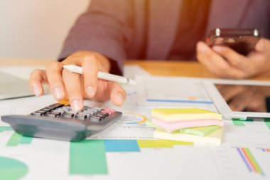 Modern ofisteki iş verilerini hesaplamak için hesap makinesi üzerinde çalışan bir iş adamı ya da muhasebeci. Mali ve vergi sistemleri kavramı