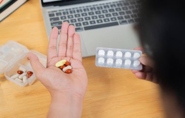 Seçici odaklı ilaçlar alarak ofis sendromu kavramı. Bir adam, elinde haplar tutan bir ofis çalışanı. Arka plan görüntüsü.