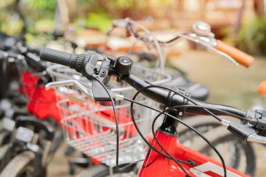 Bisikletin gidonunun yakın çekimi, sokak kenarında bir grupla park edilmiş, yan manzara. Seçici odak.