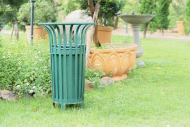 Şehir parkında ayrı atık toplama işleri için büyük yeşil çöp konteynırları. Çevre bakımı.