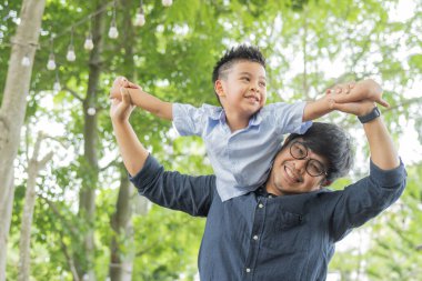 Babanın doğada oğluyla oynadığı portre. Baba ve küçük oğlu dışarıda oynayıp eğleniyorlar. Babalar günü, tatil, mutlu aile hayatı konsepti..