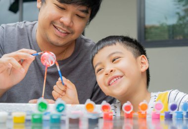 Baba ve oğul mutlu mesut gezegenleri boyuyor. Çocuklar için sanat ve zanaat... yaratıcı çocuklar oynar ve öğrenir..