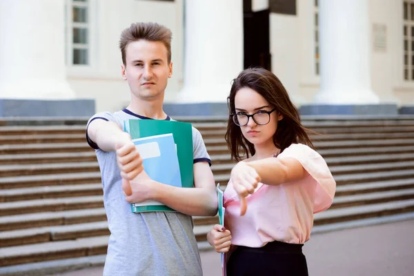 Dwoje Wściekłych Przyjaciół Studentów Trzymających Tabliczkę Kciukami Ulicy Przed Tradycyjnym — Zdjęcie stockowe