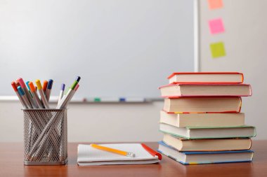 Okul malzemeleri masanın üstünde. Masada yığınla kitap, defter ve bir sürü kalem var. Eğitim, okul, üniversite, üniversite.