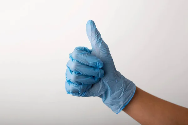 Χέρι Μπλε Γάντι Πάνω Από Ένα Γκρι Φόντο Που Δείχνει — Φωτογραφία Αρχείου