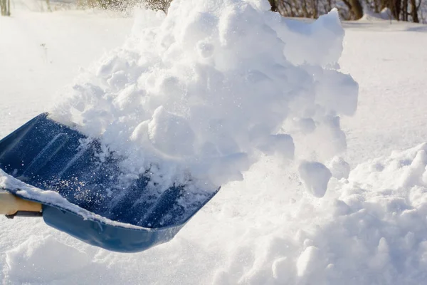 吹雪の後男は裏庭で雪を掘り庭から雪を取り除く — ストック写真
