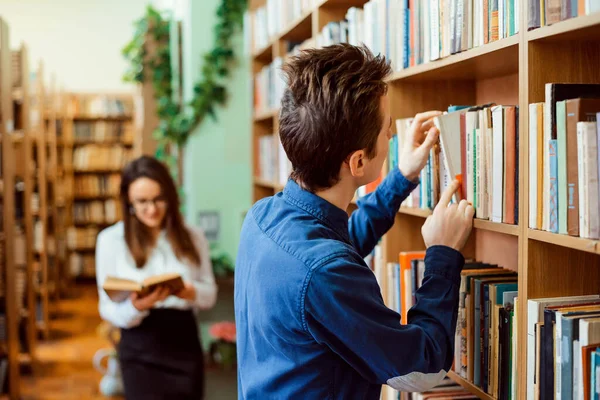 Άνδρες Και Γυναίκες Φοιτητές Που Αναζητούν Απαραίτητα Βιβλία Στη Βιβλιοθήκη — Φωτογραφία Αρχείου