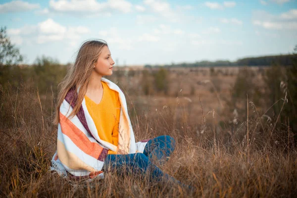 晩秋に黄色いドライフラワーと草で畑に座っている夢のような女子高生 何かや誰かを夢見ている若い女の子 — ストック写真