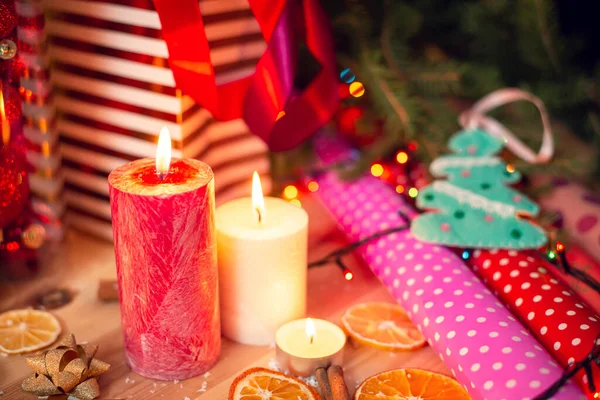 クリスマスや他の冬の休日のための準備 ろうそく 包装紙とテーブルの上にいくつかの素敵なボール — ストック写真
