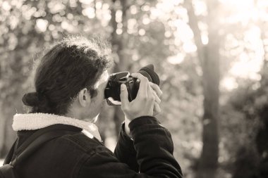 Sonbahar parkında çekilen fotoğrafçının siyah beyaz fotoğrafı. Fotoğraf konsepti