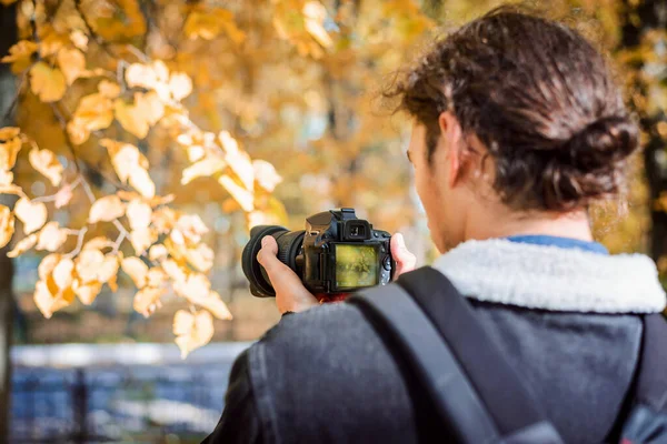 彼のカメラでカラフルな秋の公園を撮影ブロガーVloggerビデオシューティングゲームのバックビュー 秋の写真やビデオ撮影の概念 — ストック写真