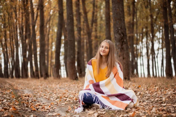 아름다운 소녀는 황금색 노란색으로 공원에 앉아서 무언가에 생각하고 있었습니다 공원에 — 스톡 사진