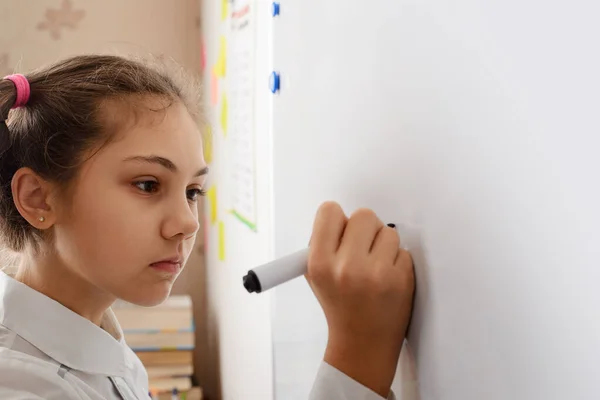 stock image Little girl writing something on board while conducting the home assignment. Education in the classroom