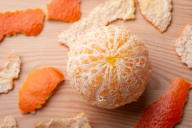 Masada mandalinayı soydum. Tahta masada taze, sulu mandalina, biraz da kabuk.