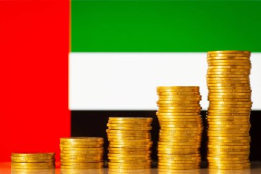Birleşik Arap Emirlikleri bayrağı önüne istiflenmiş bozuk paralardan oluşan bir grafik. Birleşik Arap Emirliklerinin hızlı finansal gelişimi kavramı