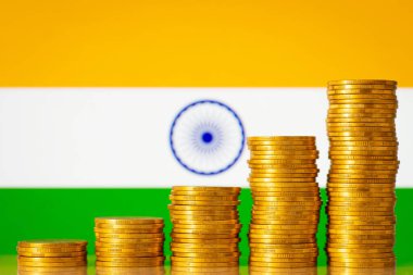 Hindistan bayrağı önünde ayaklanan altın madeni paralar yığını. Hindistan 'ın finansal sisteminin gelişimi kavramı