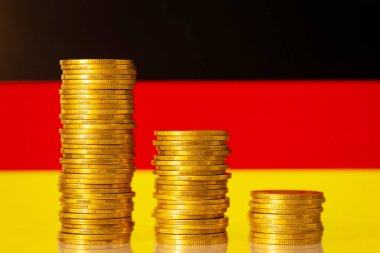 Almanya bayrağının önündeki altın para yığınları ülke ekonomisinde krizi sembolize ediyor. Ekonomi kavramının gerilemesi