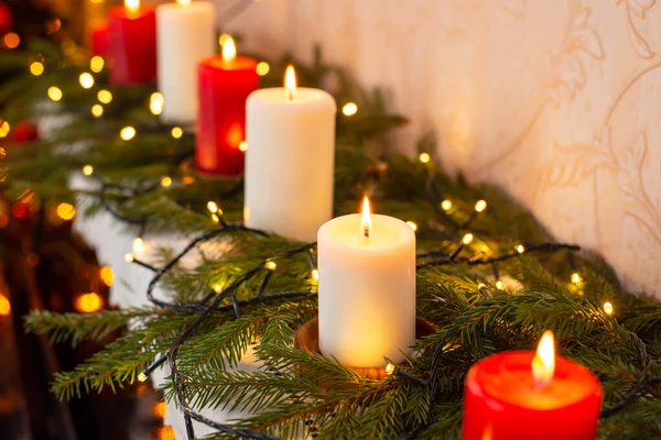 ピアノの上で赤と白のろうそくを燃やすのを閉じます 自宅でクリスマスの装飾 お祝いの雰囲気 — ストック写真