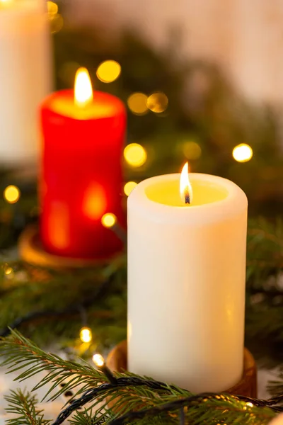 テーブルの上にライトとモミの木の枝でろうそくを燃やすのクローズアップ クリスマス飾り — ストック写真