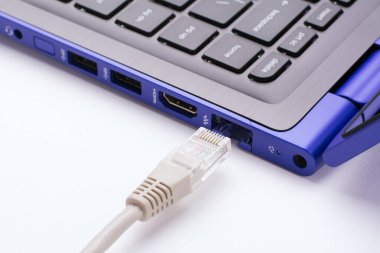 Modern mavi dizüstü bilgisayarın limanına yakın beyaz LAN internet kablosu