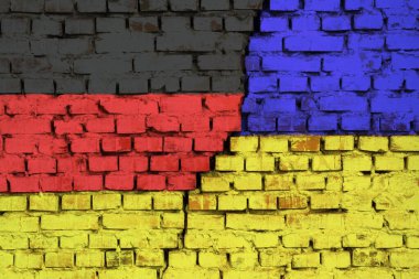Tuğla duvarda Almanya ve Ukrayna 'nın bayrakları ve ortasında büyük bir çatlak var. Ülkeler arasındaki sorunların sembolü
