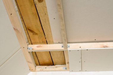 Özel bir evde ahşap çerçeve ve alçıpan kullanarak asılmış tavan yapıyor. Tavanda LED ışıklandırma için hazırlık yeri