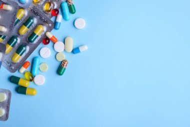 Hapların, kapsüllerin, açık mavi arka plandaki uyuşturucuların geçmişi