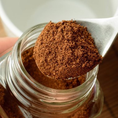 Kavanozun üstündeki kaşıktaki kahvenin ve boş fincanın fotoğrafını çek.. 