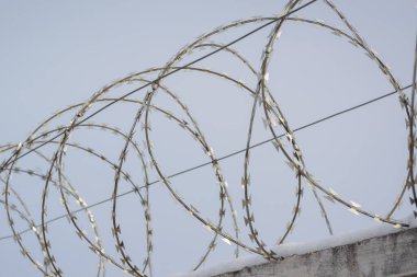Cezaevindeki savunma çitinin tepesinde elektrik voltajlı dikenli tel var.