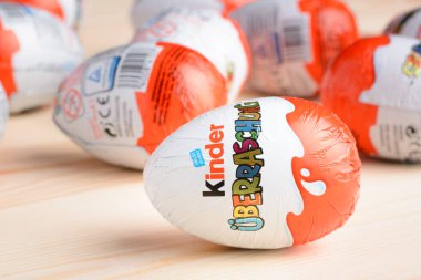 Ukrayna, Kiev - 25 Aralık 2018: Stüdyoda tahta arka planda Kinder Sürpriz Yumurtası. Ebeveynlerden tatlı bir hediye. 