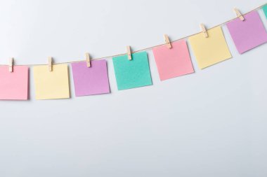 Gri arkaplana karşı bir başlık üzerine renkli boş kağıt not