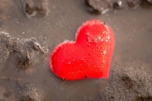 Read heart in mud. Broken heart, parting concept