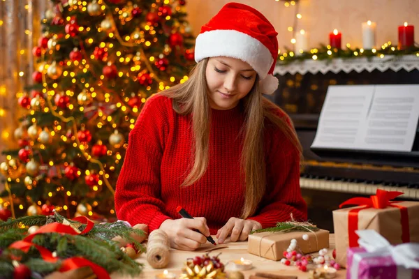 Cheerful Blond Girl Santa Hat Red Sweater Wrights Wishes Friends — 스톡 사진