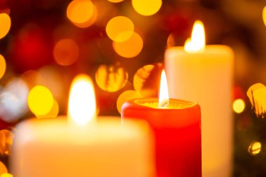 Closeup shot of red and white candles with beautiful bokeh. Burning candles, Christmas decorations