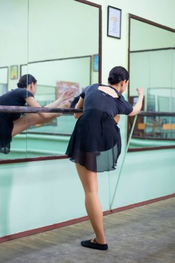Ballet dancer stretching in dancing studio. Professional dancer during the bailey practice