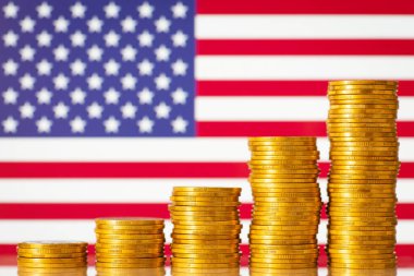Stacks of golden coins forming upward graph on background of flag of USA. Financial development of USA concept
