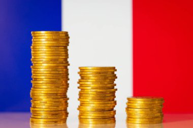 Financial crisis in France concept. Descending chart of coins in front of flag of France