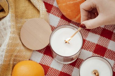 Close-up shot of igniting candle. Having picnic in autumn forest