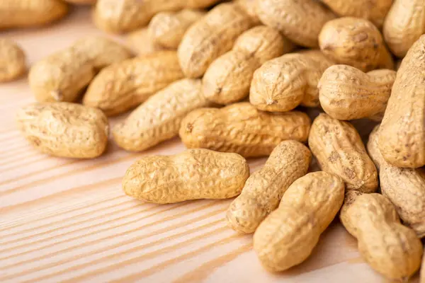 Close up shot of peanuts on wooden table. Golden peanut after roasting, fresh nuts