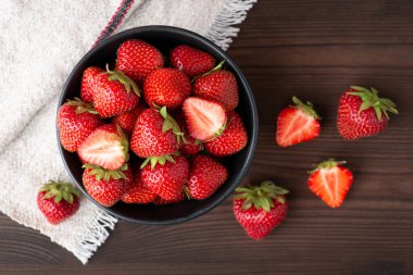 Top-down shot of ripe strawberries on black table. Just picked fresh strawberry