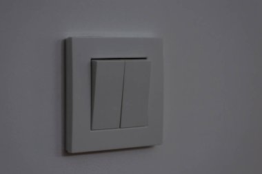 Dark room with the turned off light switch. Close up shot of two buttons for electricity on the wall in the evening
