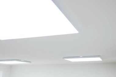Suspended ceiling with modern LED lighting. Turned on square shaped lamps for illumination