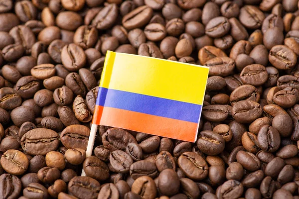 Flag of Colombia on roasted coffee beans. Concept of growing coffee in Colombia